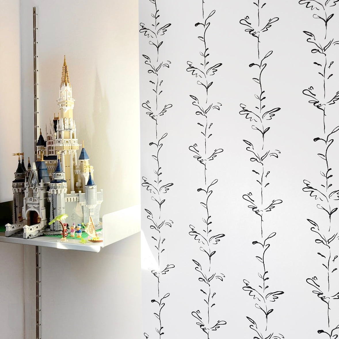 Stem black and white wallpaper by Polly Dunbar with a Lego castle on a shelf